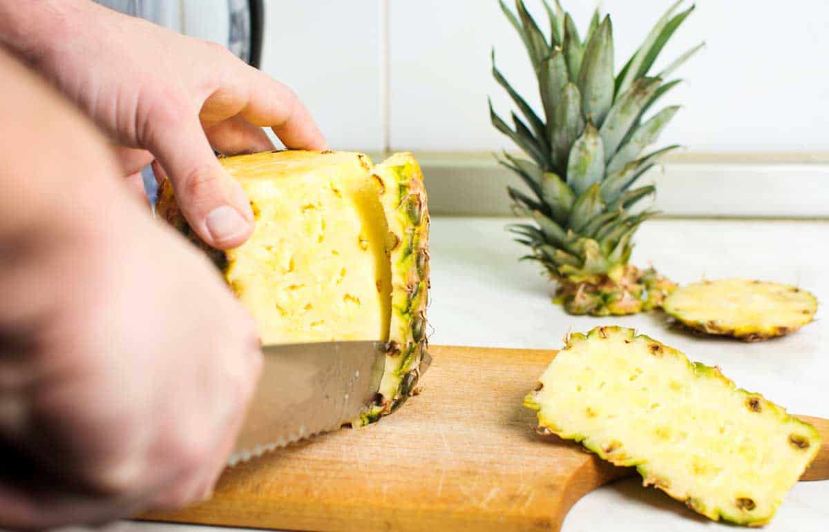 cutting skin off pineapple